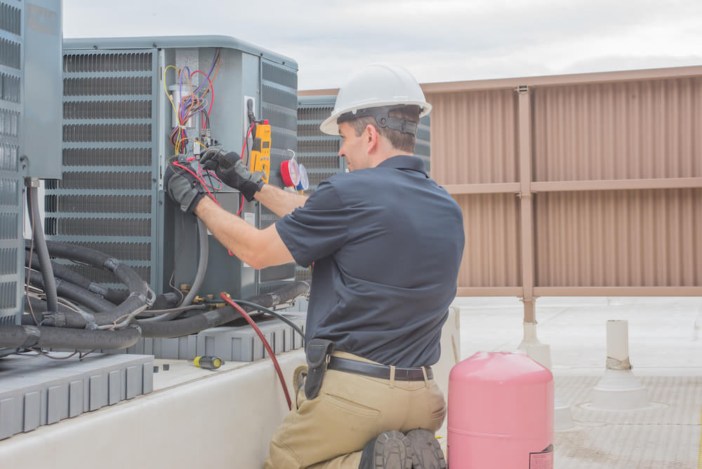 Technician responding to an emergency AC repair call at night, emphasizing 24/7 service availability