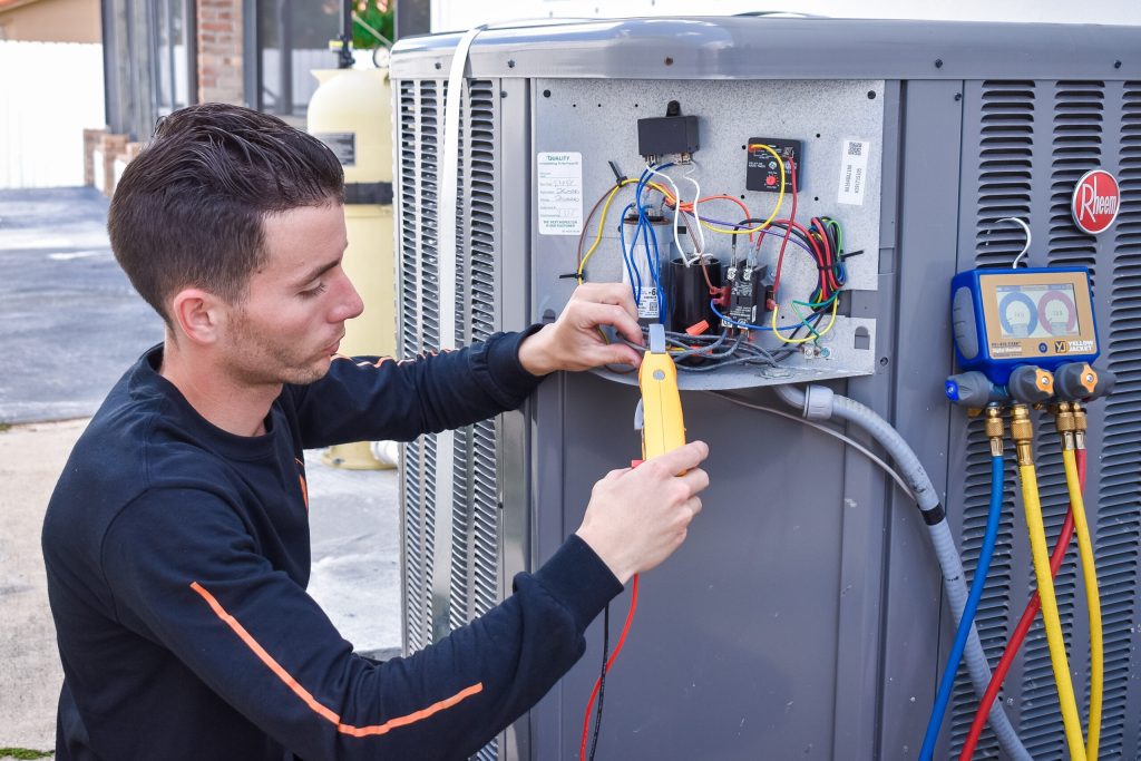 Cooling expert performing maintenance on an AC unit, DSC-0393, ensuring optimal performance and energy efficiency in Miami, FL homes.