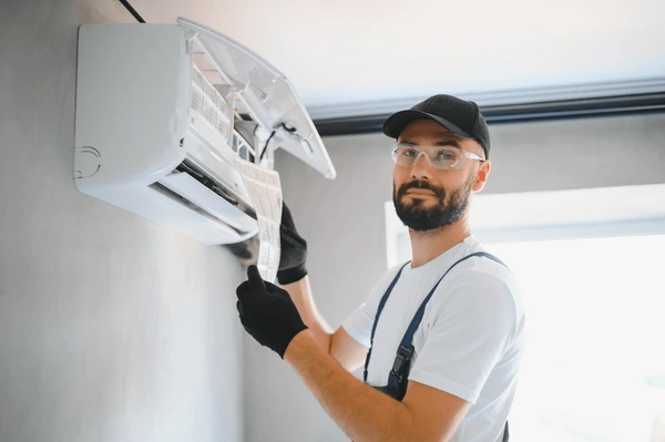 Technician examining common air conditioning problems in a Hialeah home, highlighting maintenance issues