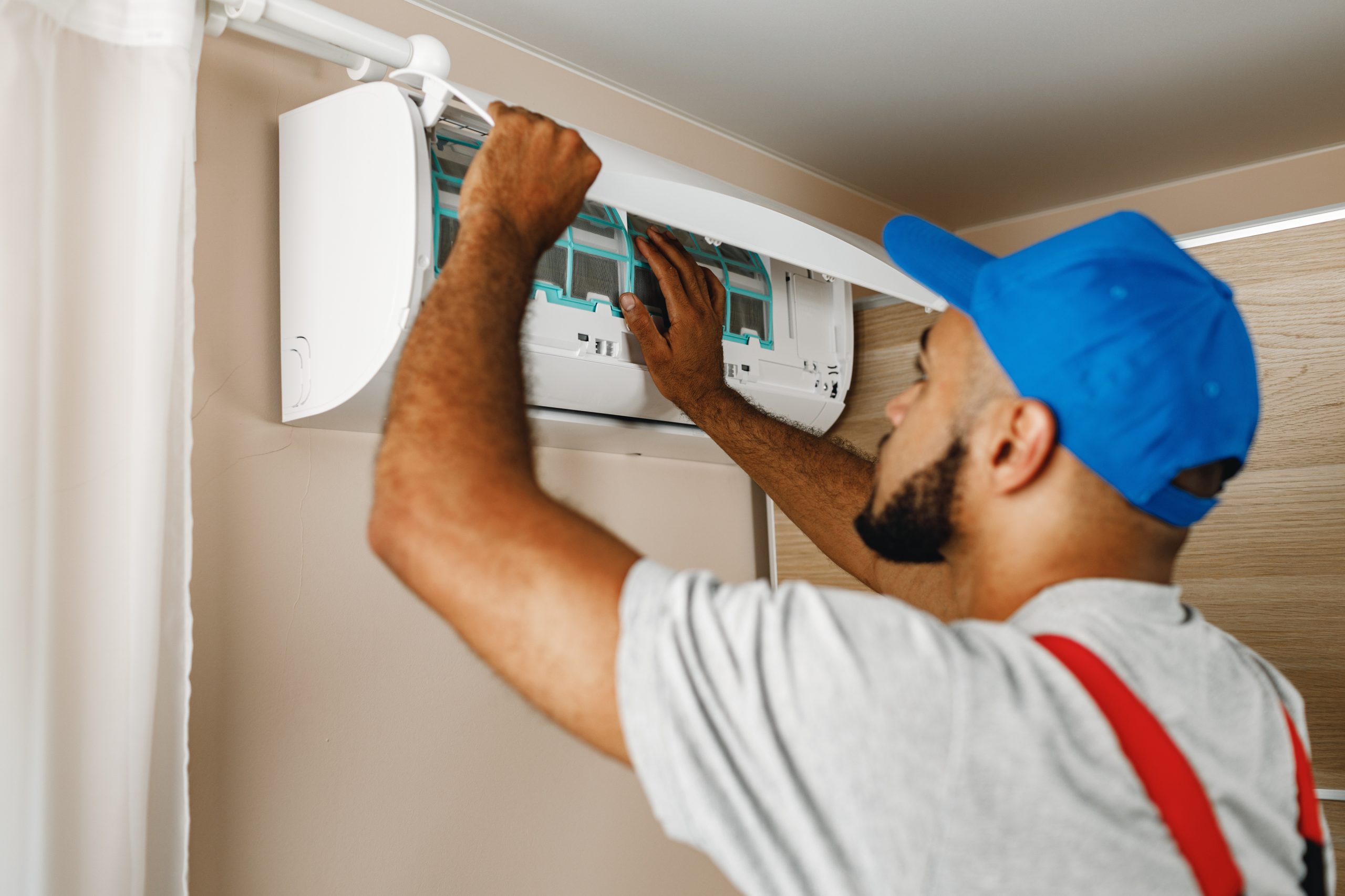 A clean air conditioner filter being installed, with a bright, well-maintained AC unit in the background